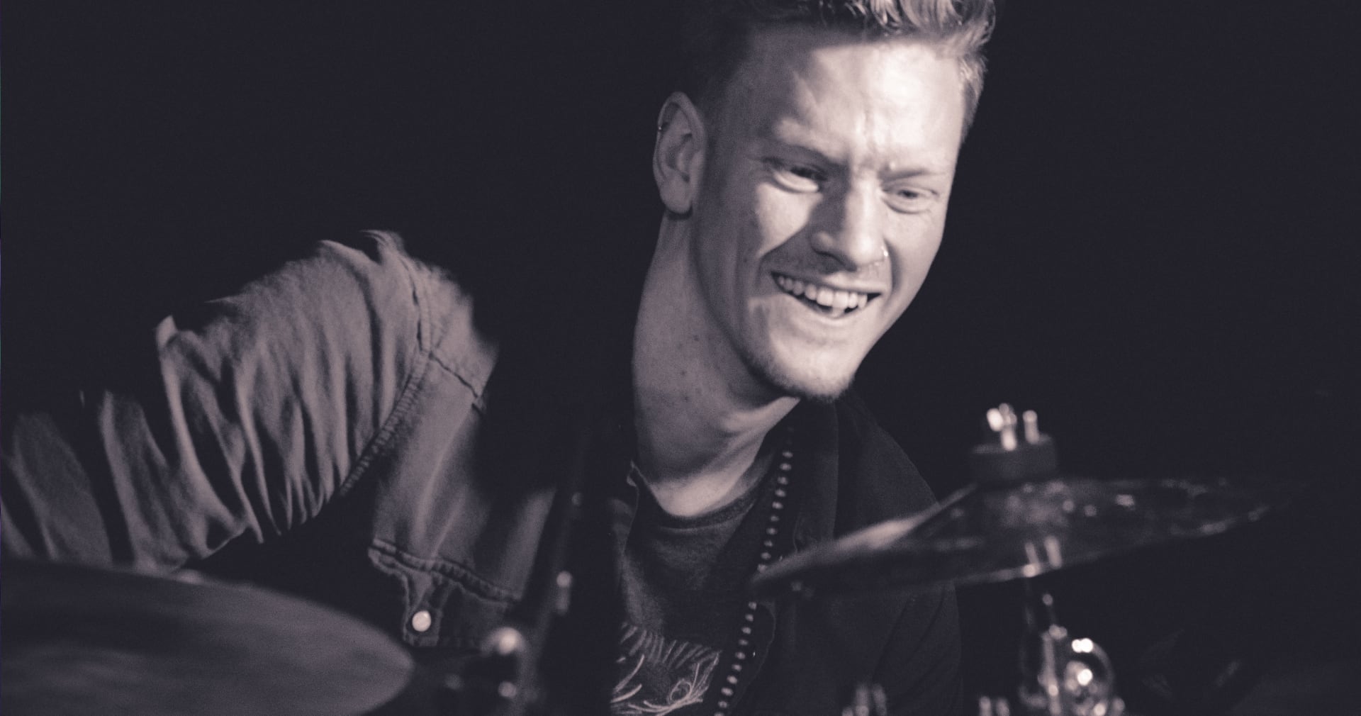 Alex Campbell grinning behind the kit mid-set